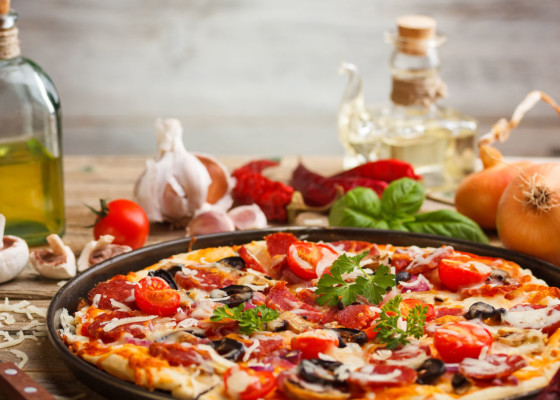 Pizza with salami, olives and goat cheese